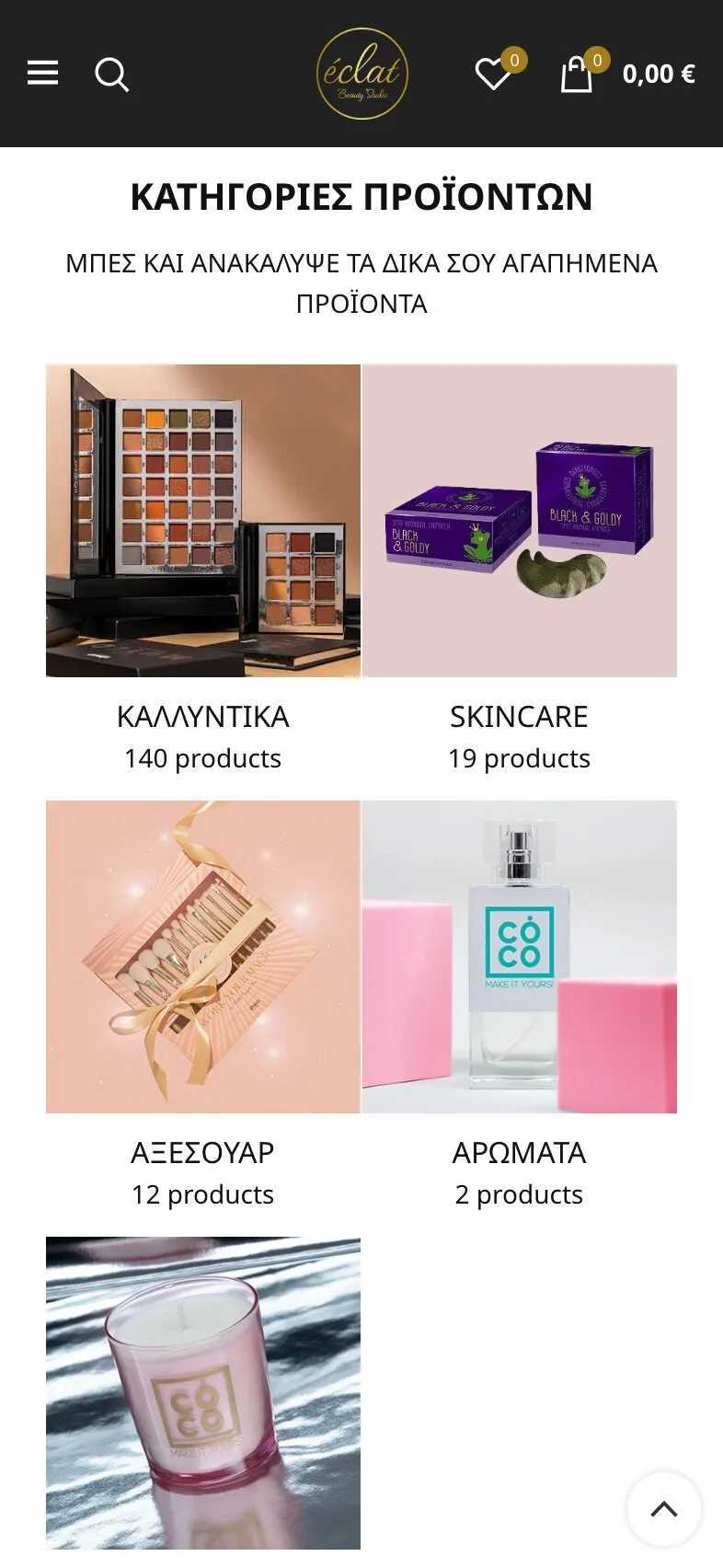 The product categories on a phone, in Greek: a black header with a menu button, search, the gold logo, the wishlist and the cart at 0,00 €, then the heading "ΚΑΤΗΓΟΡΙΕΣ ΠΡΟΪΟΝΤΩΝ" (product categories), a line inviting visitors to discover their favourite products, and a two-column grid of photographs with counts: cosmetics, 140 products; skincare, 19; accessories, 12; perfumes, 2; and a fifth photograph, a candle in a pink glass. A round back-to-top button sits at the bottom right.