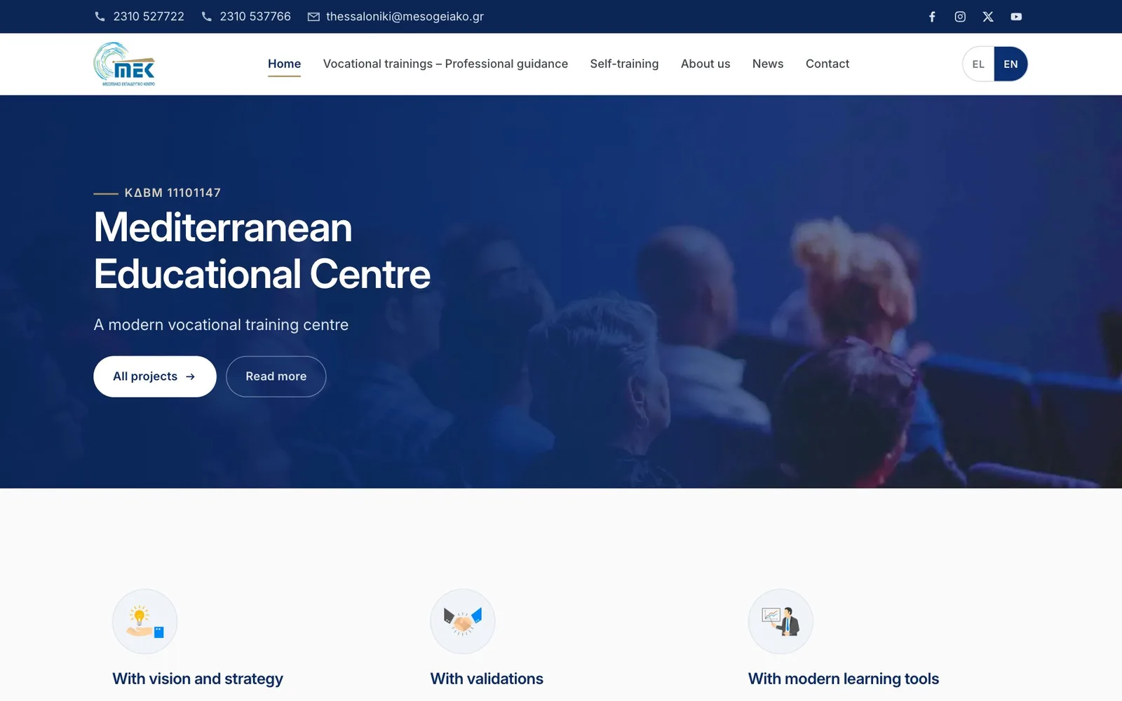 The English home page: a navy top bar with two phone numbers, an email address and social icons, the logo and menu with Home underlined and EN selected, and over a blue-tinted photo of an audience seen from behind, the line "ΚΔΒΜ 11101147", the heading "Mediterranean Educational Centre", the line "A modern vocational training centre", a white "All projects" button and an outlined "Read more" button; three round icons with headings begin below.
