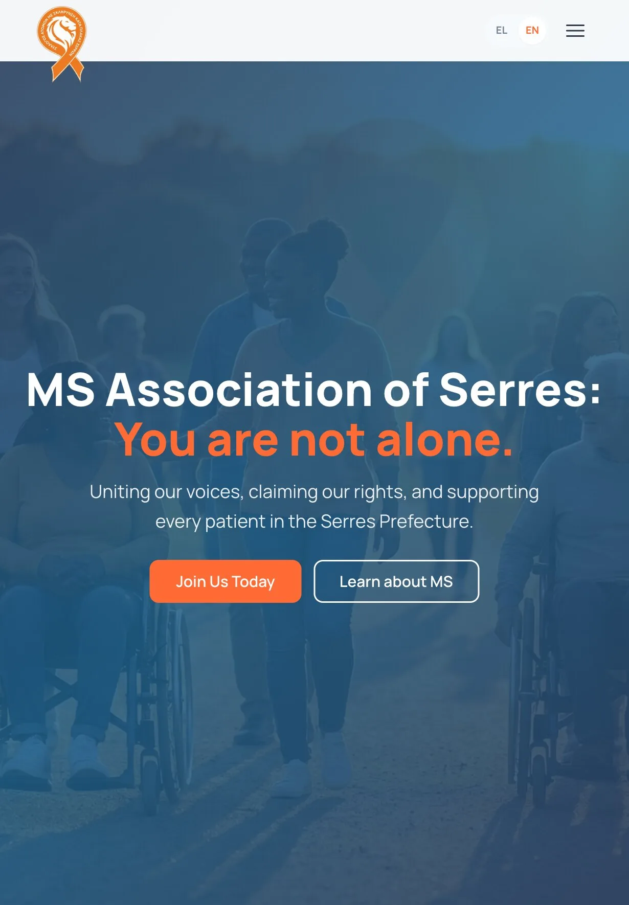 The home page on a tablet: the ribbon logo, the EL/EN switch and a menu button above the blue-tinted photograph of people walking outdoors, some in wheelchairs; centred on it, the headline "MS Association of Serres: You are not alone." on two lines, the supporting line, and the "Join Us Today" and "Learn about MS" buttons side by side.