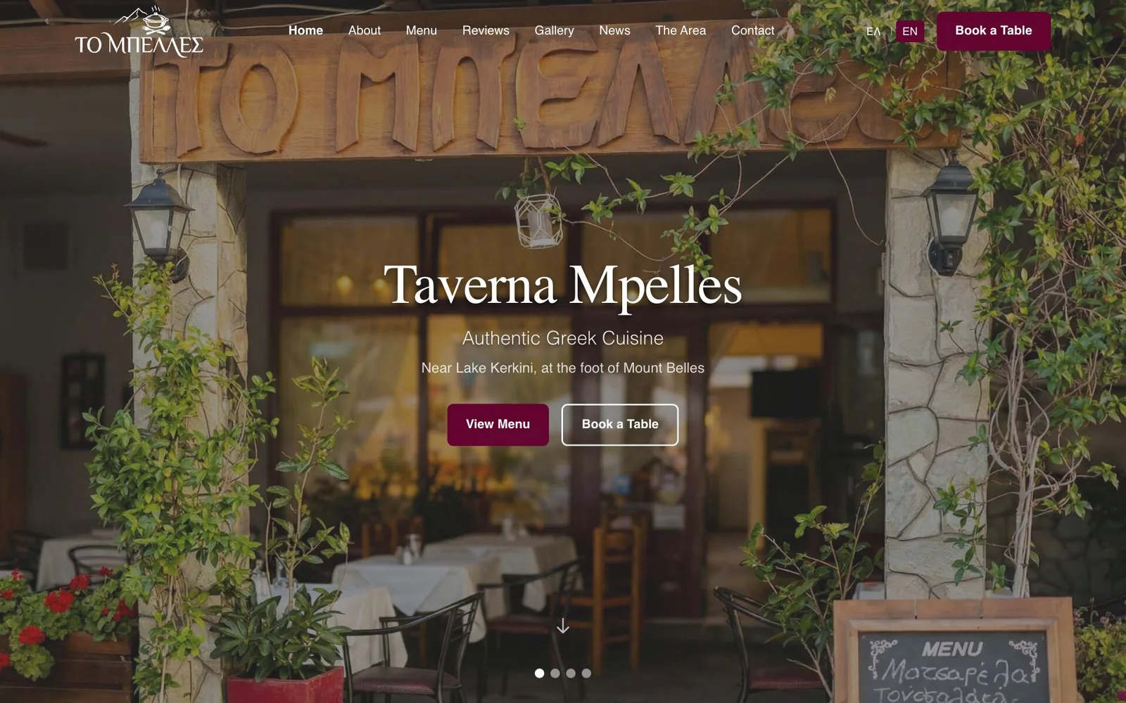 The Taverna Mpelles home page: the ΤΟ ΜΠΕΛΛΕΣ logo, a menu of Home, About, Menu, Reviews, Gallery, News, The Area and Contact, an ΕΛ | EN switch and a "Book a Table" button, over a photograph of the taverna's entrance — a carved wooden sign reading "ΤΟ ΜΠΕΛΛΕΣ" on stone pillars with lanterns and climbing plants, tables with white cloths inside and a chalkboard menu in the corner; in the middle the heading "Taverna Mpelles", the lines "Authentic Greek Cuisine" and "Near Lake Kerkini, at the foot of Mount Belles", a "View Menu" button and an outlined "Book a Table" button, with four slide dots below.